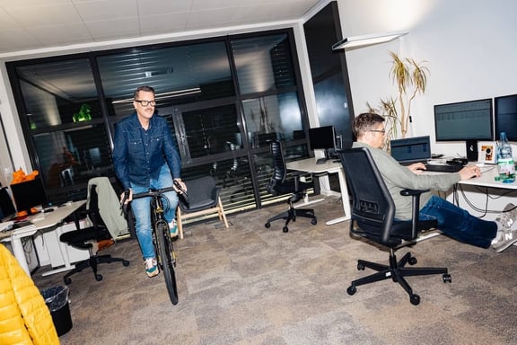 Berater der m&z Agency fährt Fahrrad im Büro