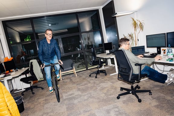 Berater der m&z Agency fährt Fahrrad im Büro