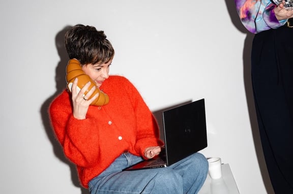 Beraterin der m&z Agency mit Pozellan-Croissant als Telefon