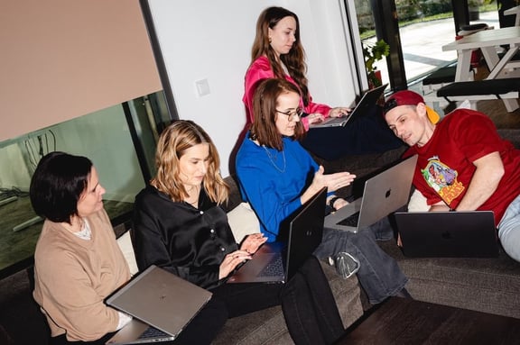 Team der m&z Agency mit Laptops auf Couch