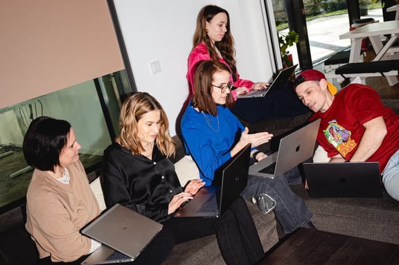 Team der m&z Agency mit Laptops auf Couch