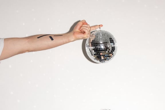 In der m&z Agency hält eine Hand eine Discokugel