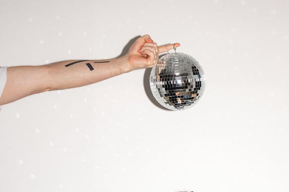 In der m&z Agency hält eine Hand eine Discokugel