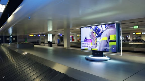 Fraport Kampagnen-Motiv auf Bildschirm an der Gepäckausgabe