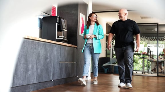 Mitarbeitende im Gespräch an der Kaffeemaschine